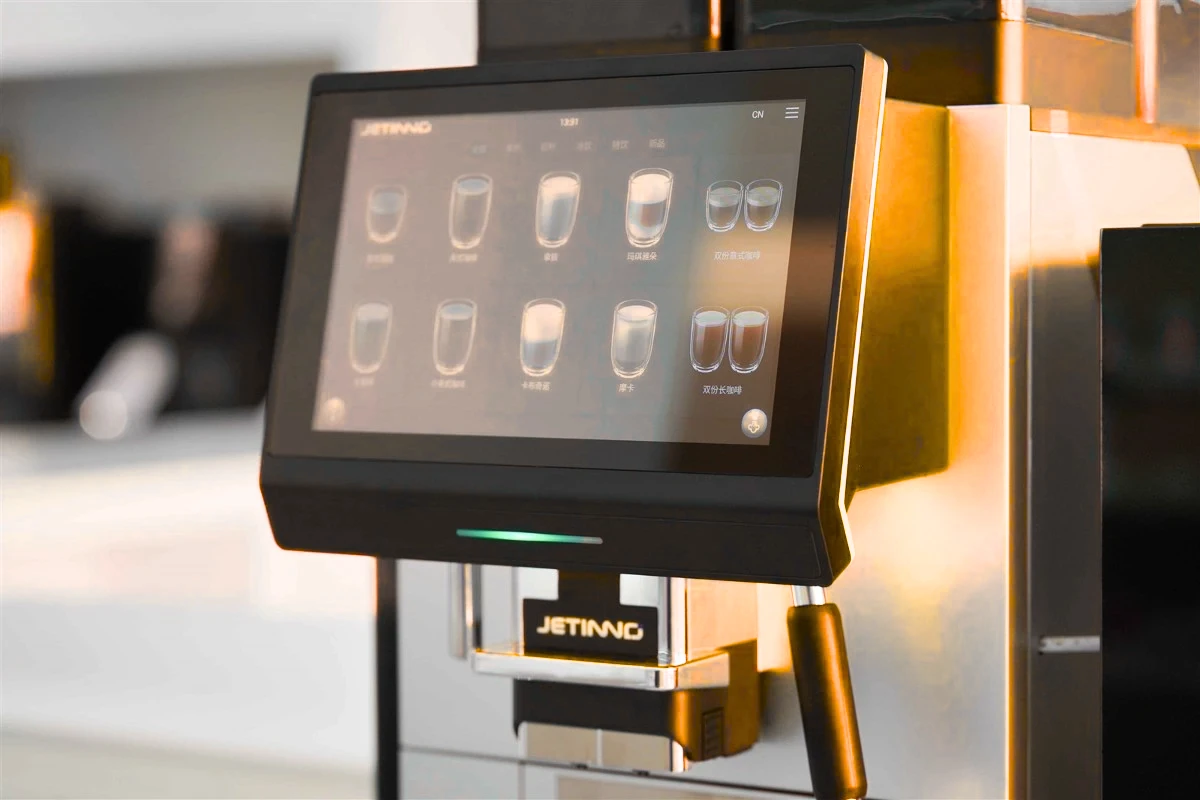 Detalle de una máquina Jetinno: pantalla táctil, salida de café y acabados metálicos