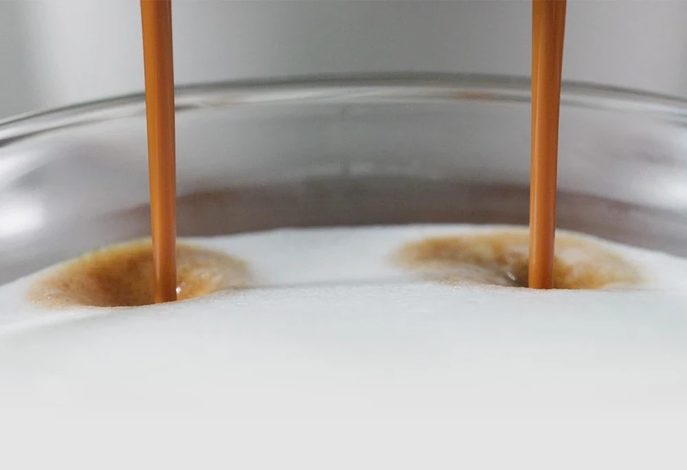 Detalle del espresso mezclándose con la espuma de leche fresca